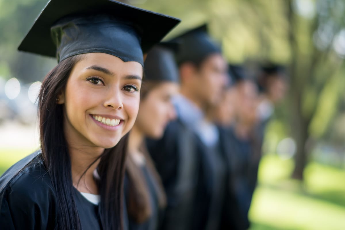 A graduate smiling in cap and gown